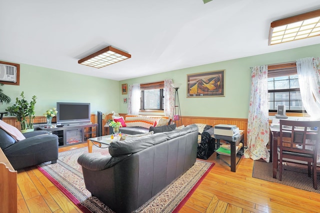 living area featuring a wealth of natural light, a wainscoted wall, and hardwood / wood-style floors