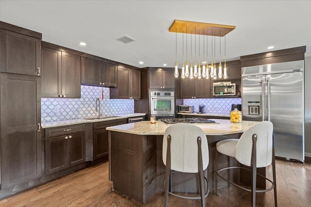 498 Teal Plz, Secaucus, NJ 07094 - kitchen with appliances with stainless steel finishes, a sink, dark brown cabinets, a kitchen island, and light stone countertops