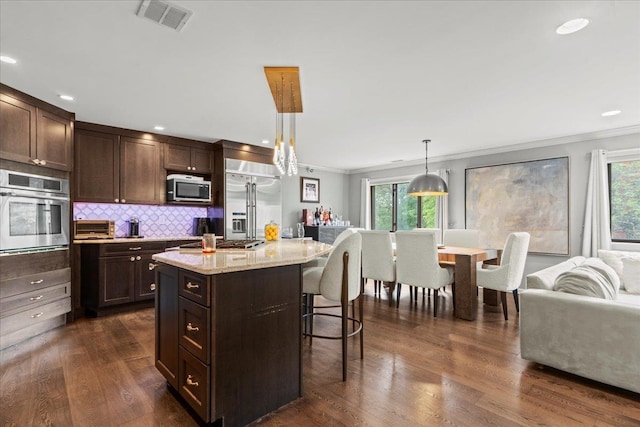 498 Teal Plz, Secaucus, NJ 07094 - kitchen with appliances with stainless steel finishes, crown molding, plenty of natural light, a breakfast bar, and dark brown cabinets