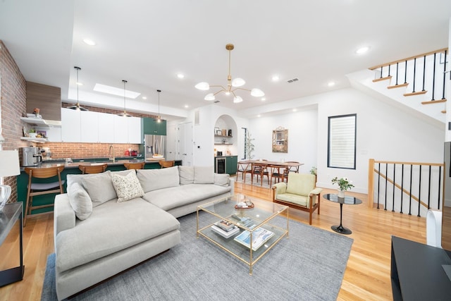 72 Lincoln St Unit 2, Jersey City, NJ 07307 - living room with light wood-style flooring, arched walkways, a chandelier, stairs, and recessed lighting
