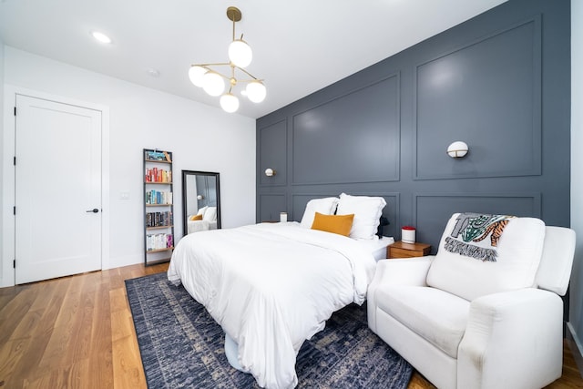 72 Lincoln St Unit 2, Jersey City, NJ 07307 - bedroom featuring a decorative wall, wood finished floors, and a chandelier
