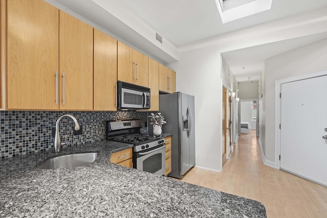 512 Jefferson St Unit 4R, Hoboken, NJ 07030 - kitchen with stainless steel appliances, dark stone countertops, decorative backsplash, light wood finished floors, and a skylight