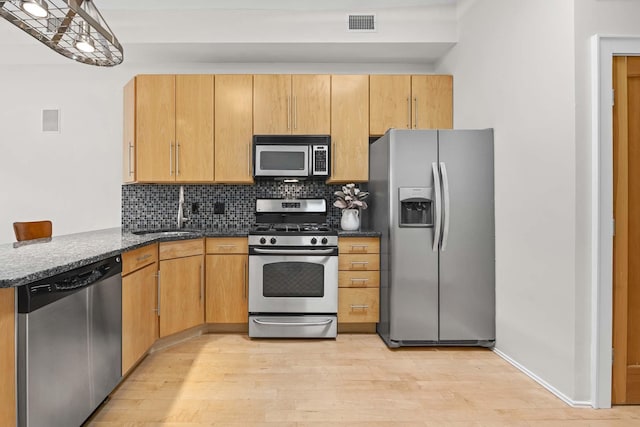 512 Jefferson St Unit 4R, Hoboken, NJ 07030 - kitchen with stainless steel appliances, light wood-style floors, decorative backsplash, and dark stone counters