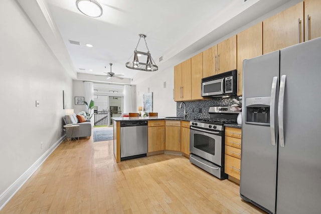 512 Jefferson St Unit 4R, Hoboken, NJ 07030 - kitchen featuring appliances with stainless steel finishes, a peninsula, open floor plan, light wood-style flooring, and tasteful backsplash