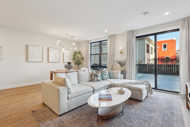 living room featuring recessed lighting, visible vents, light wood-type flooring, and baseboards