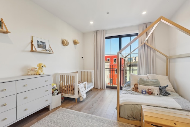 bedroom featuring recessed lighting, wood finished floors, and access to exterior