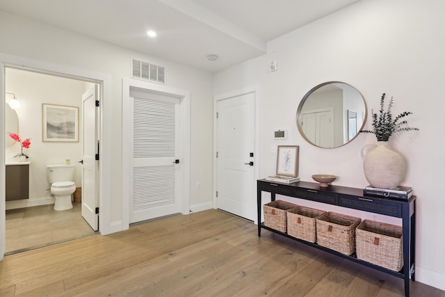 entryway with light wood-style floors, visible vents, and baseboards