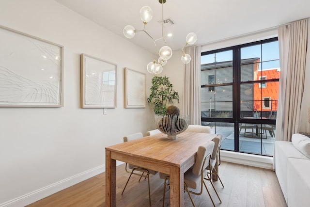 dining room featuring light wood-style flooring, visible vents, and baseboards