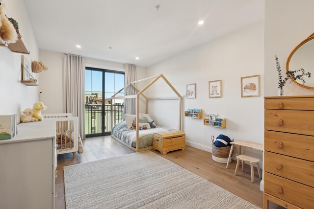 bedroom with recessed lighting, baseboards, wood finished floors, and access to exterior