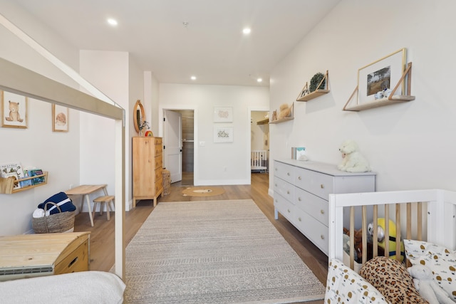 bedroom featuring radiator, recessed lighting, wood finished floors, and baseboards