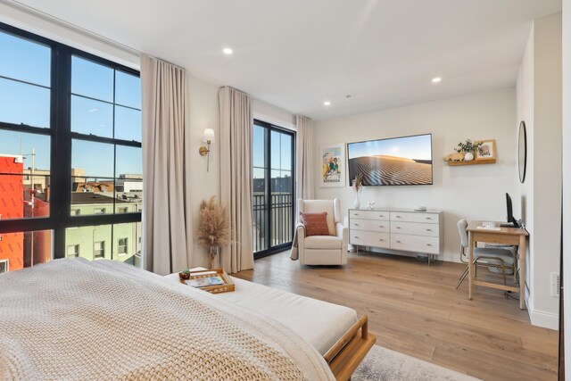 bedroom with access to exterior, recessed lighting, wood finished floors, and baseboards