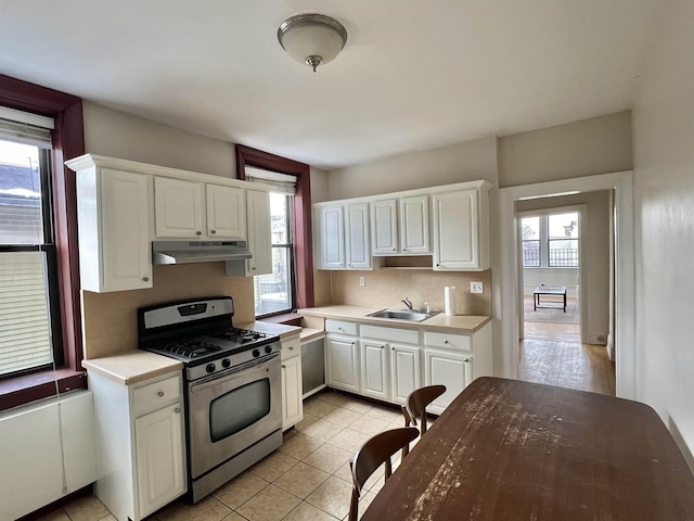 kitchen with stainless steel range with gas cooktop, sink, a wealth of natural light, and white cabinets