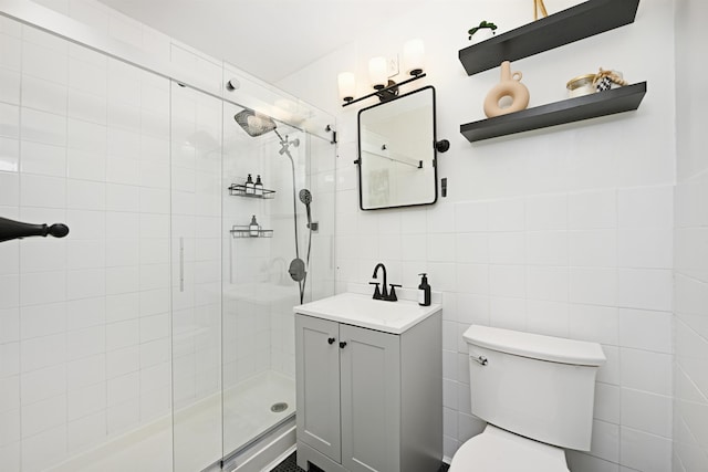 bathroom with vanity, toilet, tile walls, and walk in shower