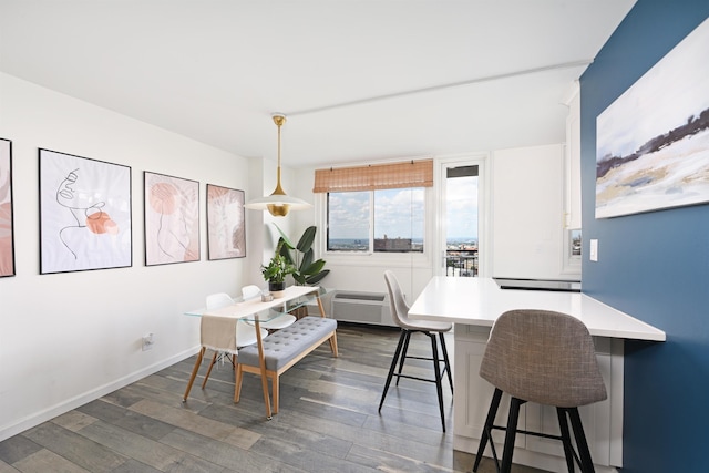 dining area with a wall mounted air conditioner and dark hardwood / wood-style floors