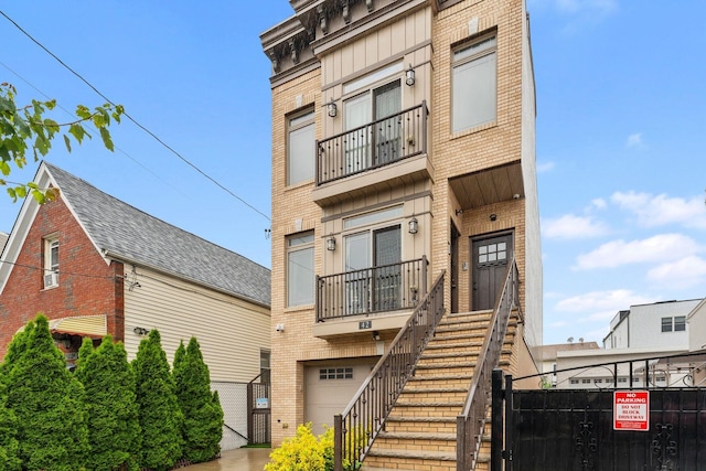 42 Grace St Unit 2, Jersey City, NJ 07307 - view of front of house featuring brick siding, a balcony, an attached garage, a gate, and stairway