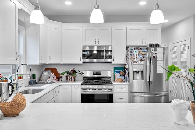 42 Grace St Unit 2, Jersey City, NJ 07307 - kitchen featuring stainless steel appliances, white cabinets, hanging light fixtures, recessed lighting, and light stone counters