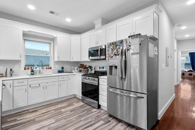 42 Grace St Unit 2, Jersey City, NJ 07307 - kitchen featuring stainless steel appliances, light wood-style flooring, white cabinetry, light countertops, and recessed lighting