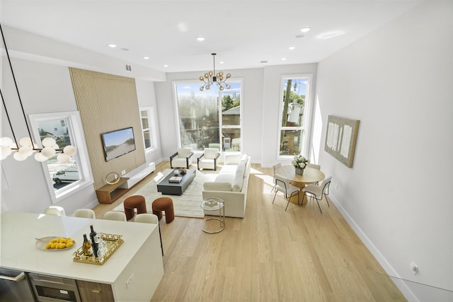 living area featuring recessed lighting, light wood-type flooring, baseboards, and a chandelier