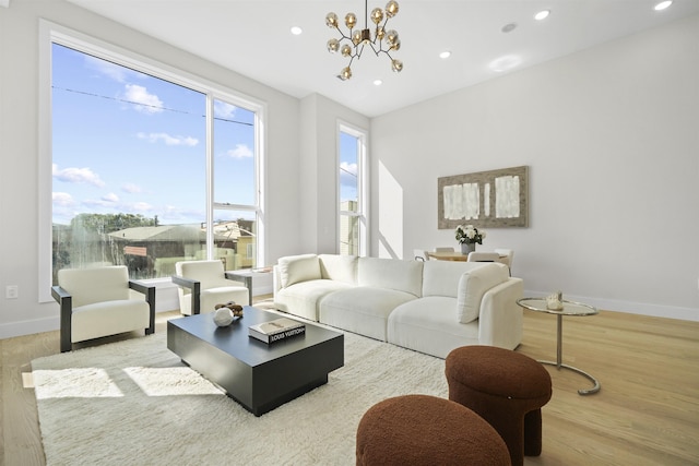 living room featuring recessed lighting, a chandelier, baseboards, and wood finished floors