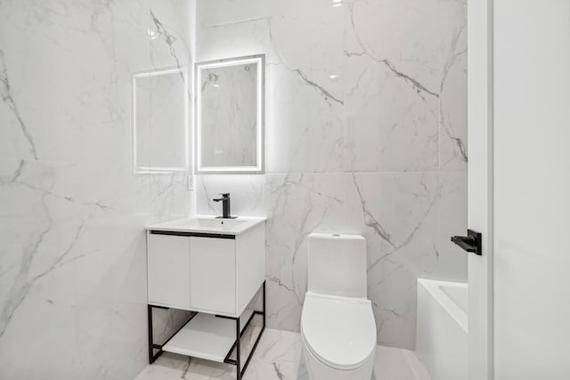 bathroom featuring vanity, a bathing tub, and toilet