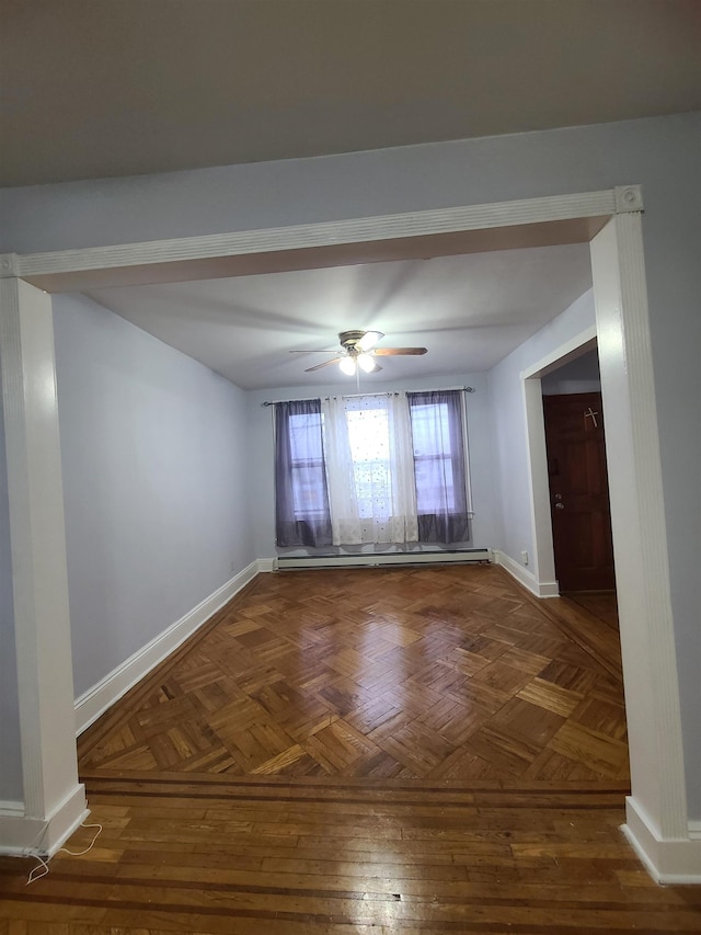 empty room with a baseboard heating unit, baseboards, and a ceiling fan