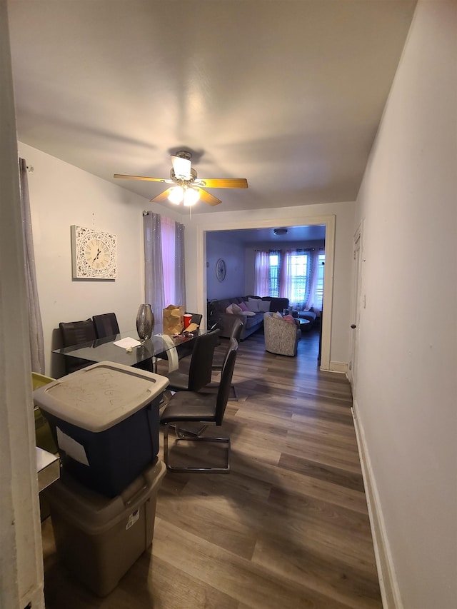 dining area featuring wood finished floors, baseboards, and ceiling fan