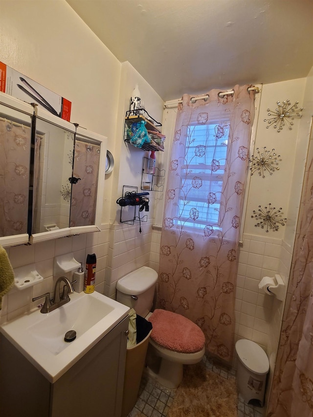 bathroom featuring a wainscoted wall, toilet, tile walls, and vanity