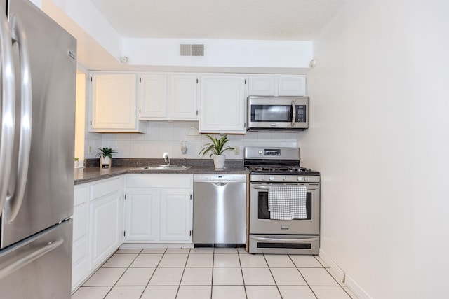 kitchen featuring visible vents, backsplash, appliances with stainless steel finishes, white cabinetry, and a sink