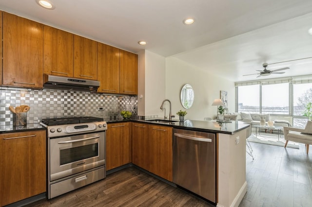 kitchen with sink, stainless steel appliances, tasteful backsplash, and kitchen peninsula