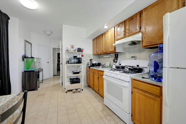 215 48th St Unit 101, Union City, NJ 07087 - kitchen featuring white appliances, under cabinet range hood, light countertops, light tile patterned floors, and backsplash