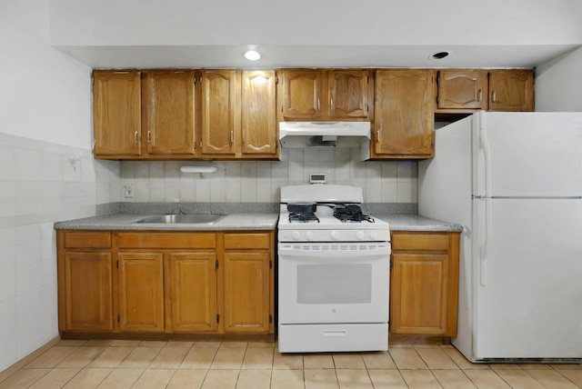 215 48th St Unit 101, Union City, NJ 07087 - kitchen with white appliances, under cabinet range hood, brown cabinets, and a sink