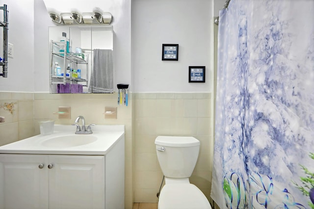 215 48th St Unit 101, Union City, NJ 07087 - bathroom with tile walls, vanity, toilet, a shower with shower curtain, and wainscoting