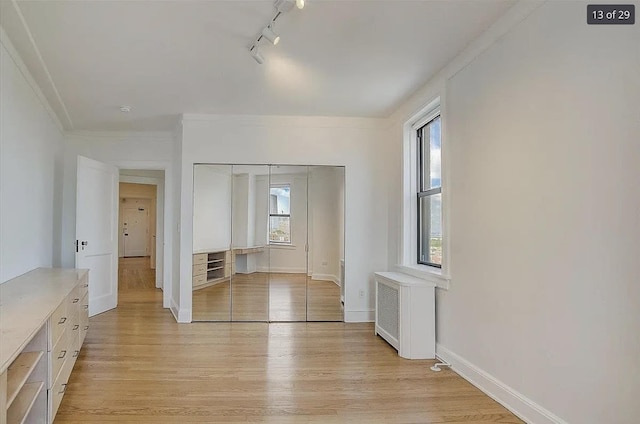 2600 Kennedy Blvd Unit 7A, Jersey City, NJ 07306 - unfurnished bedroom with radiator heating unit, track lighting, light wood-style flooring, a closet, and ornamental molding