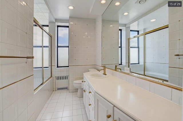 2600 Kennedy Blvd Unit 7A, Jersey City, NJ 07306 - bathroom featuring radiator heating unit, tile patterned flooring, tile walls, plenty of natural light, and vanity