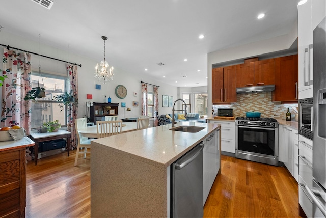 390 1st St Unit 3, Jersey City, NJ 07302 - kitchen featuring appliances with stainless steel finishes, under cabinet range hood, light wood-type flooring, plenty of natural light, and recessed lighting