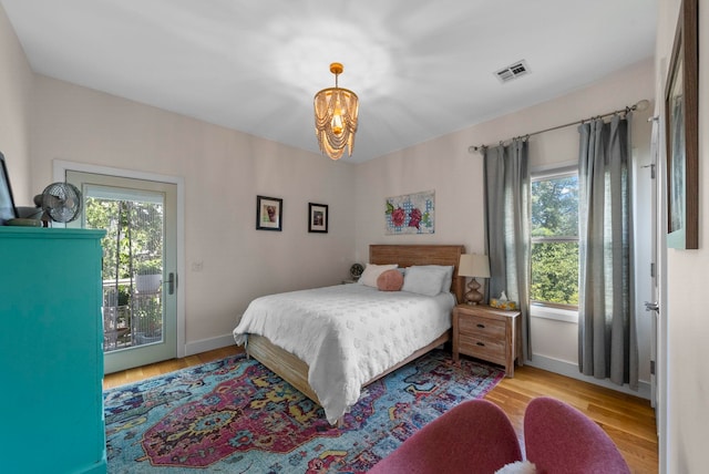 390 1st St Unit 3, Jersey City, NJ 07302 - bedroom featuring access to outside, a chandelier, multiple windows, and wood finished floors