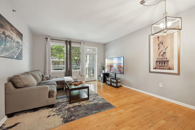 living room with hardwood / wood-style floors and an inviting chandelier