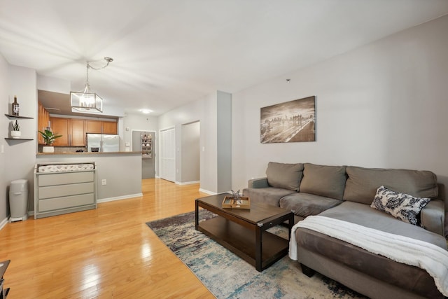 living room with an inviting chandelier and light hardwood / wood-style flooring