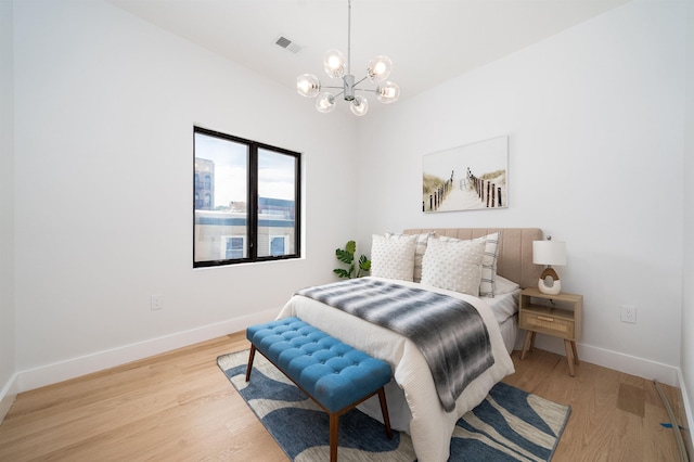 bedroom featuring light hardwood / wood-style flooring and a chandelier