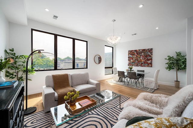 living room featuring a notable chandelier and light hardwood / wood-style flooring