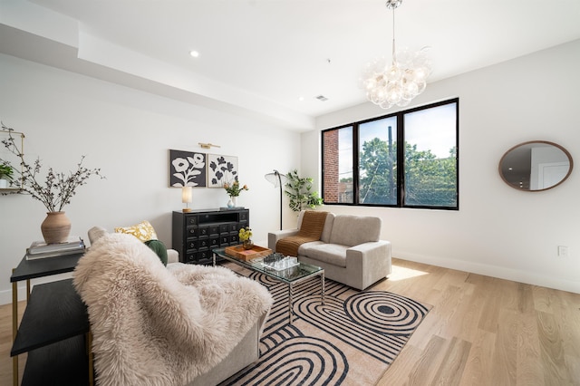 living room featuring an inviting chandelier and light hardwood / wood-style floors