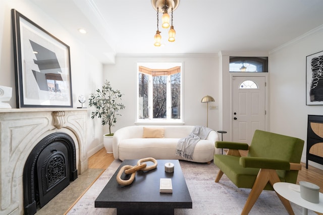 living room featuring crown molding, a fireplace, and light hardwood / wood-style floors