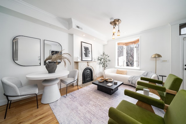 living room with ornamental molding and light wood-type flooring