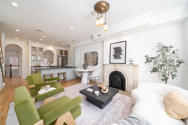 living room with ornamental molding and light hardwood / wood-style flooring