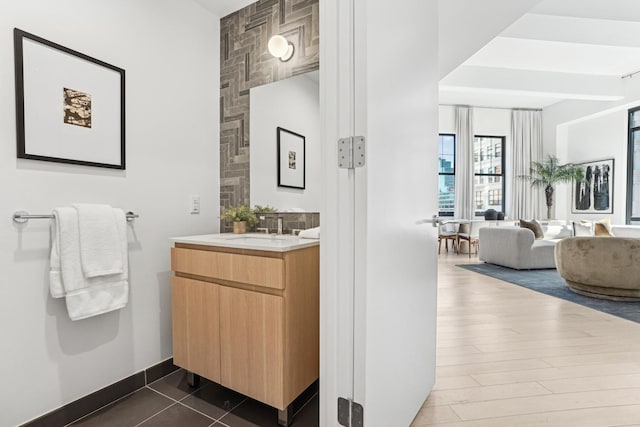bathroom featuring vanity, wood finished floors, and baseboards
