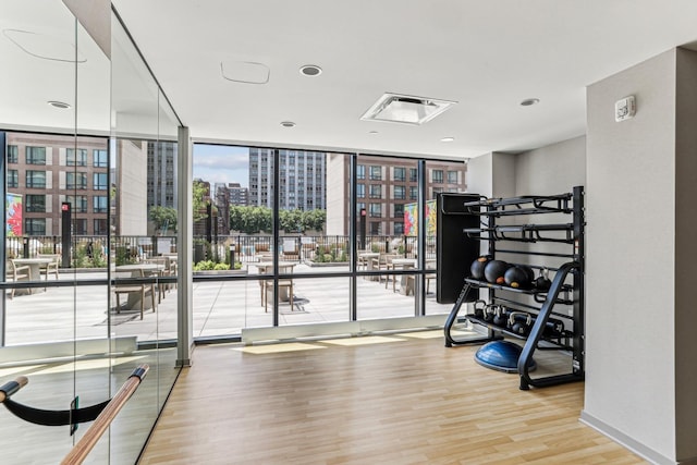 interior space with a city view, wood finished floors, and expansive windows