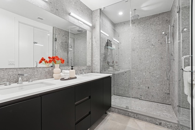 full bathroom with tile patterned floors, visible vents, a stall shower, and a sink