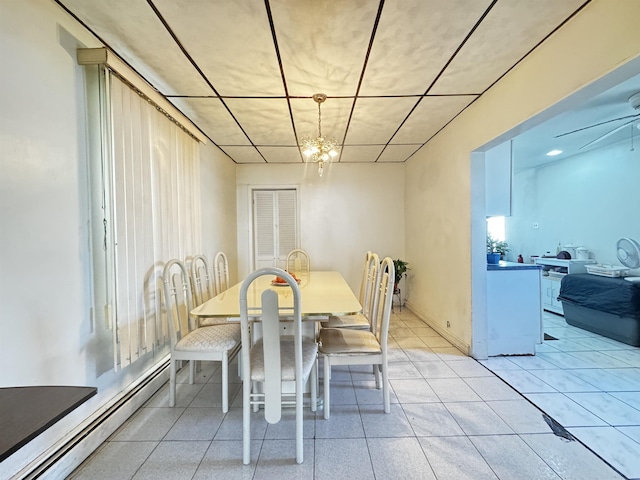 dining area with ceiling fan with notable chandelier and a baseboard heating unit