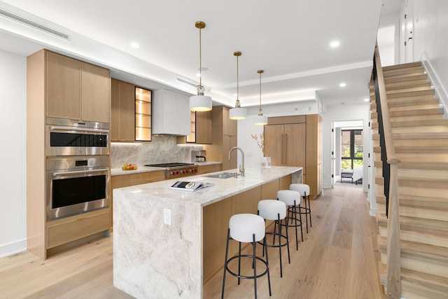 906 Park Ave Unit 1, Hoboken, NJ 07030 - kitchen featuring a sink, appliances with stainless steel finishes, light wood finished floors, modern cabinets, and backsplash