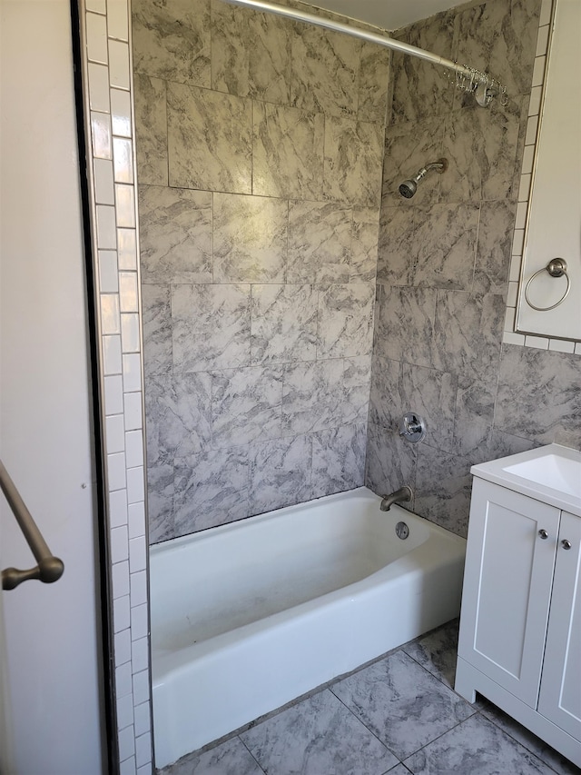 bathroom featuring tiled shower / bath combo, sink, and tile walls